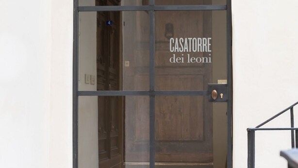 Eine Tür mit dem Schriftzug "CASATORRE dei leoni" und einem Messing-Türknauf.