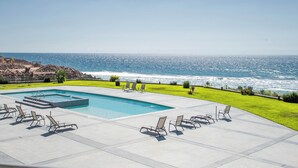 Ein Pool mit Liegestühlen und Blick auf den Ozean.