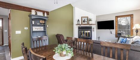 A dining area with a wooden table, chairs, and a ceiling fan.