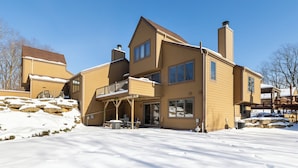 A large, two-story house with a balcony and a covered patio area. - Cozy Retreat at Farmstead (Galena)