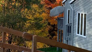 A cabin with a wooden deck and a view of autumn foliage. - O'Tremblant-Nature with Fireplace/Plein air avec foyer (Mont-Tremblant)