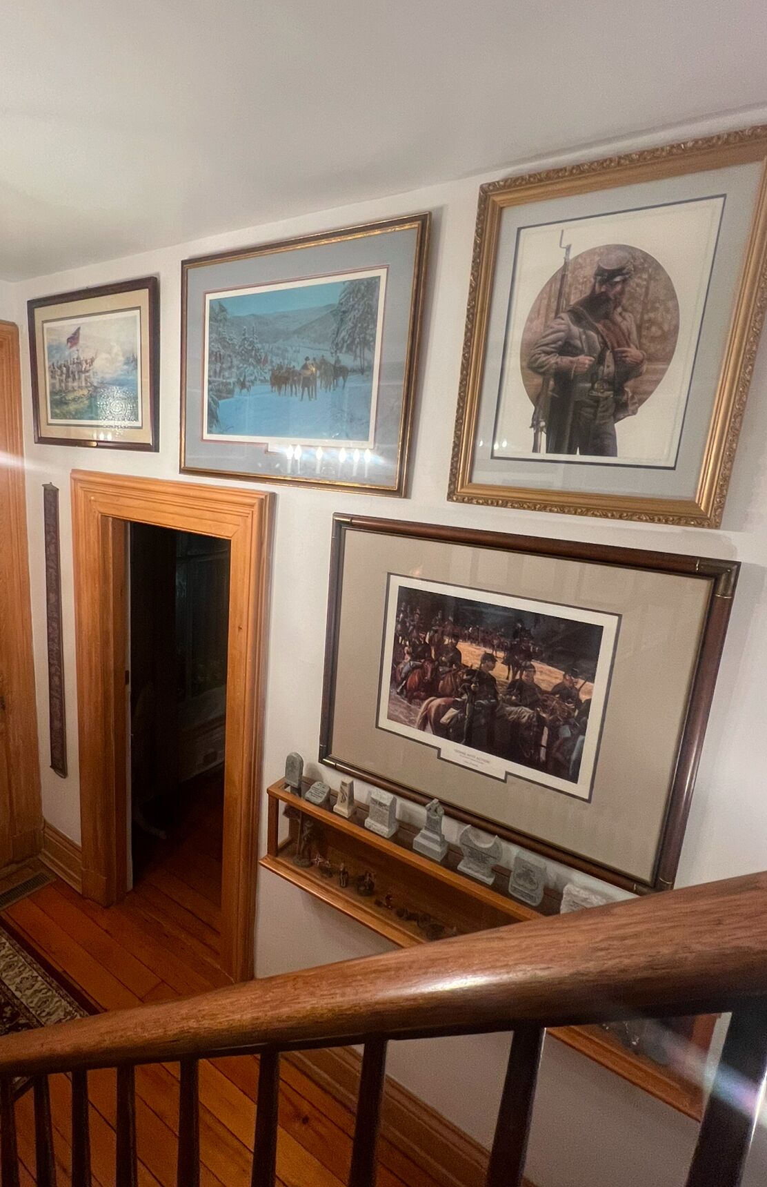 A staircase with wooden railings and a wall adorned with framed historical photographs.