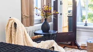 A cozy room with a vintage-style mirror, a vase with flowers, and a window with curtains. - Lincoln Suite in charming Olinger House B&B in historic, downtown Gettysburg. (Gettysburg)