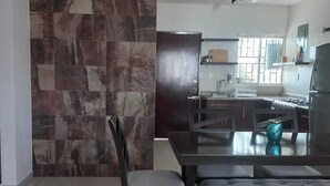 A modern kitchen with a stone backsplash, a dining area with a bench, and a refrigerator. - Family apartment with excellent location (Tampico)