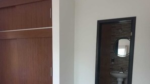 A bedroom with a bed, a wardrobe, and a bathroom visible through an open door. - Family apartment with excellent location (Tampico)