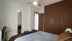 Ein Schlafzimmer mit einem großen Bett, einem Holzschrank, einem Deckenventilator und einer Heizung.