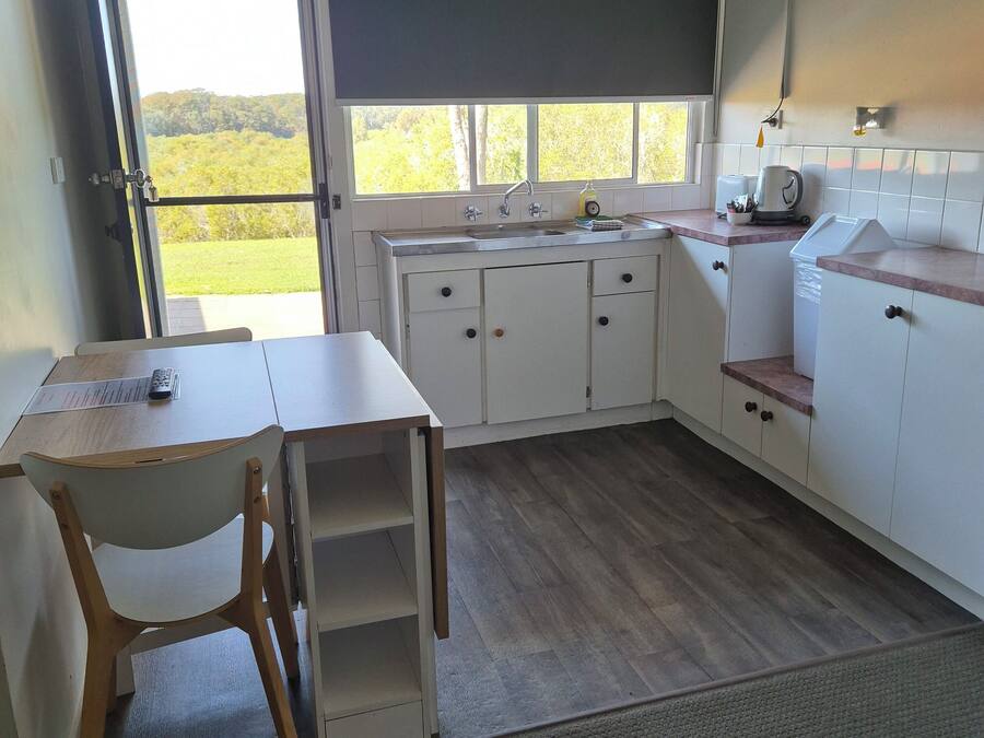 Una cocina compacta con ventana, un lavamanos y una pequeña zona de comedor.