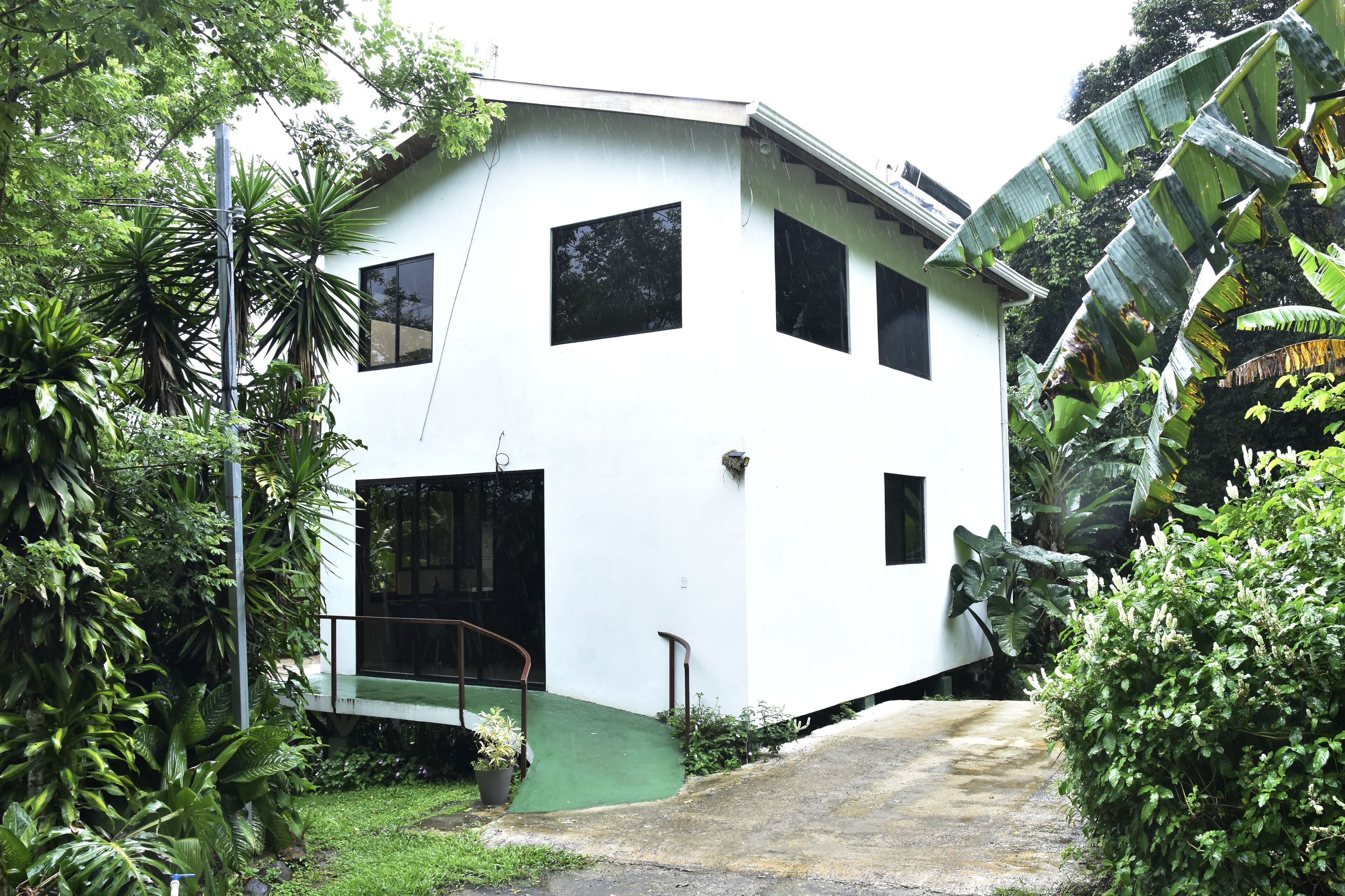 A white building with multiple windows and a green entrance.