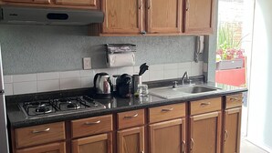 Una cocina con armarios de madera, una estufa a gas, un lavamanos y una encimera.