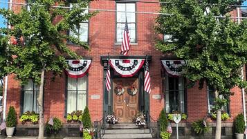 A brick building with a central entrance, American flags, and patriotic decorations.