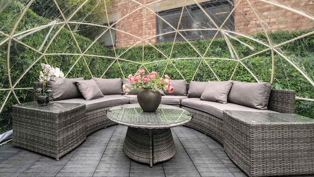 A covered outdoor seating area with a round table, cushioned sofa, and a potted plant. - Stunning 4BR 3BA in the ♥️ of London ❄️ Air Con. 🌿 Private Garden | Sleeps 10 (Greater London)