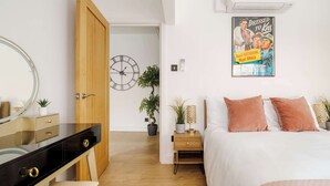 Ein Schlafzimmer mit einem Bett, einem Nachttisch und einem Bild an der Wand.