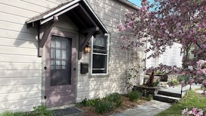 A house with a front door, a small porch, and a garden with flowering plants. - Charming loft cottage in tranquil Germantown with WiFi, AC (Germantown)