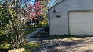 A small, single-story building with a garage door, a sign instructing to park on the left and not block the garage door. - Charming loft cottage in tranquil Germantown with WiFi, AC (Germantown)