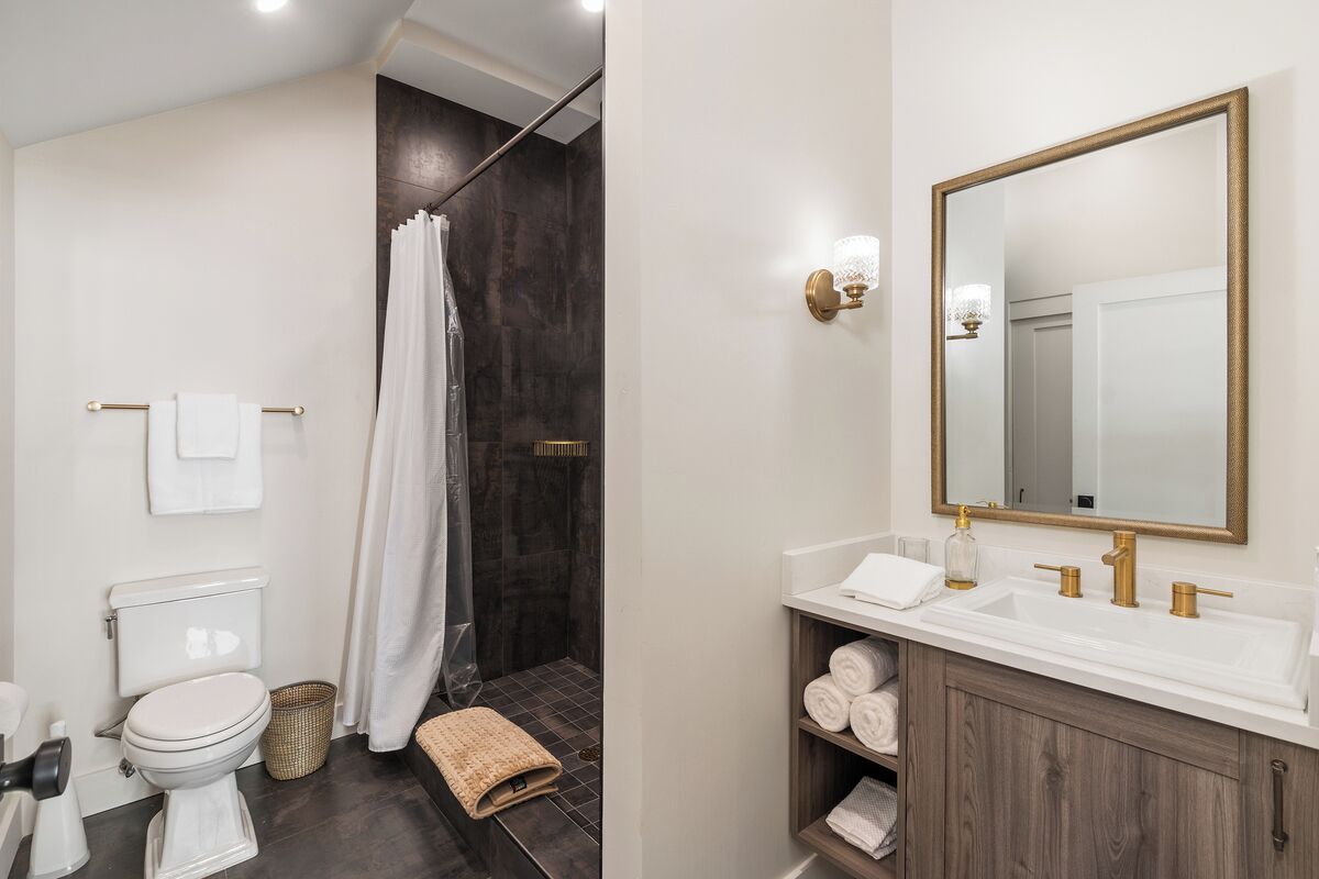 A modern bathroom with a shower, toilet, and vanity.