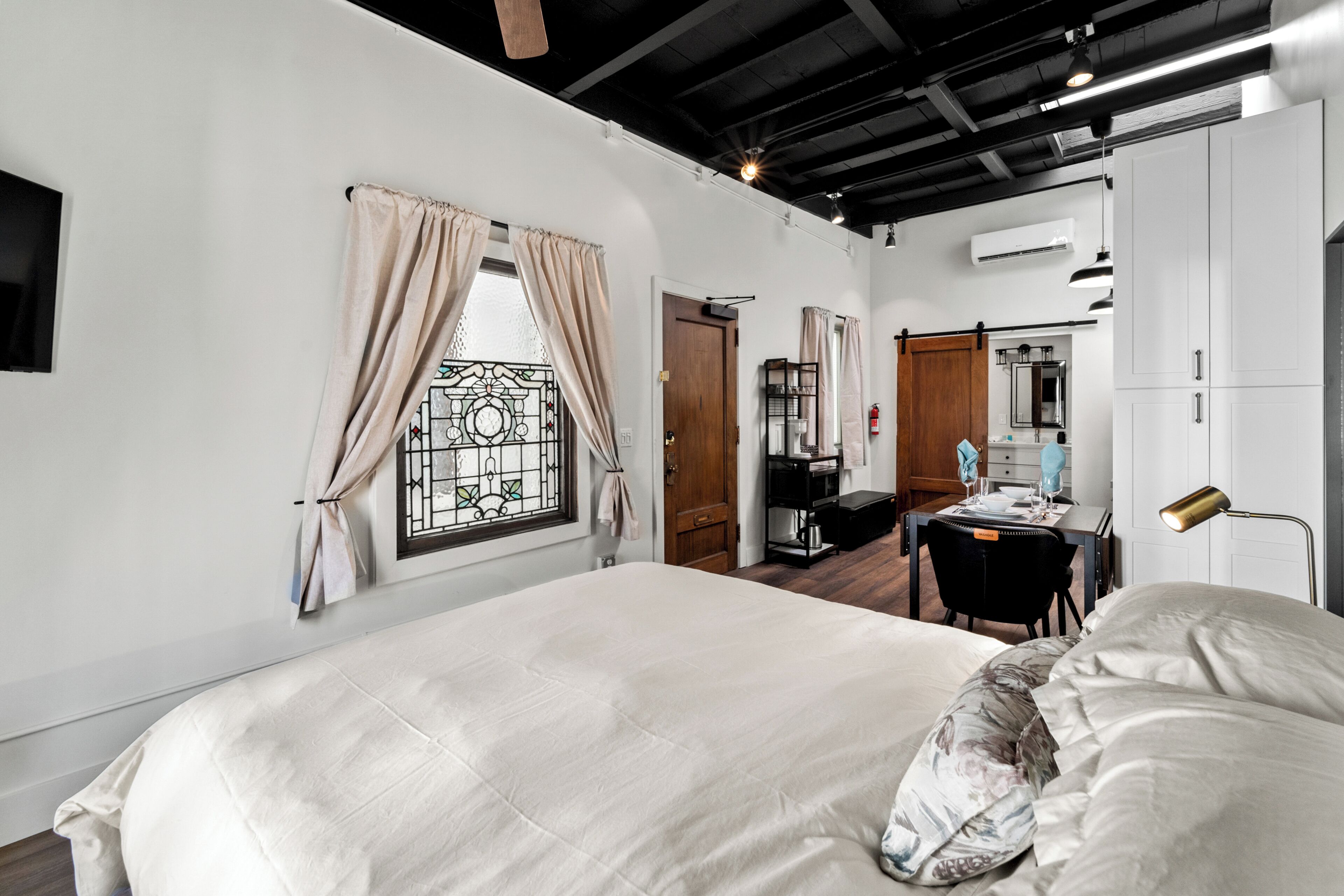 Quarto com uma cama grande, uma escrivaninha e um guarda-roupa.