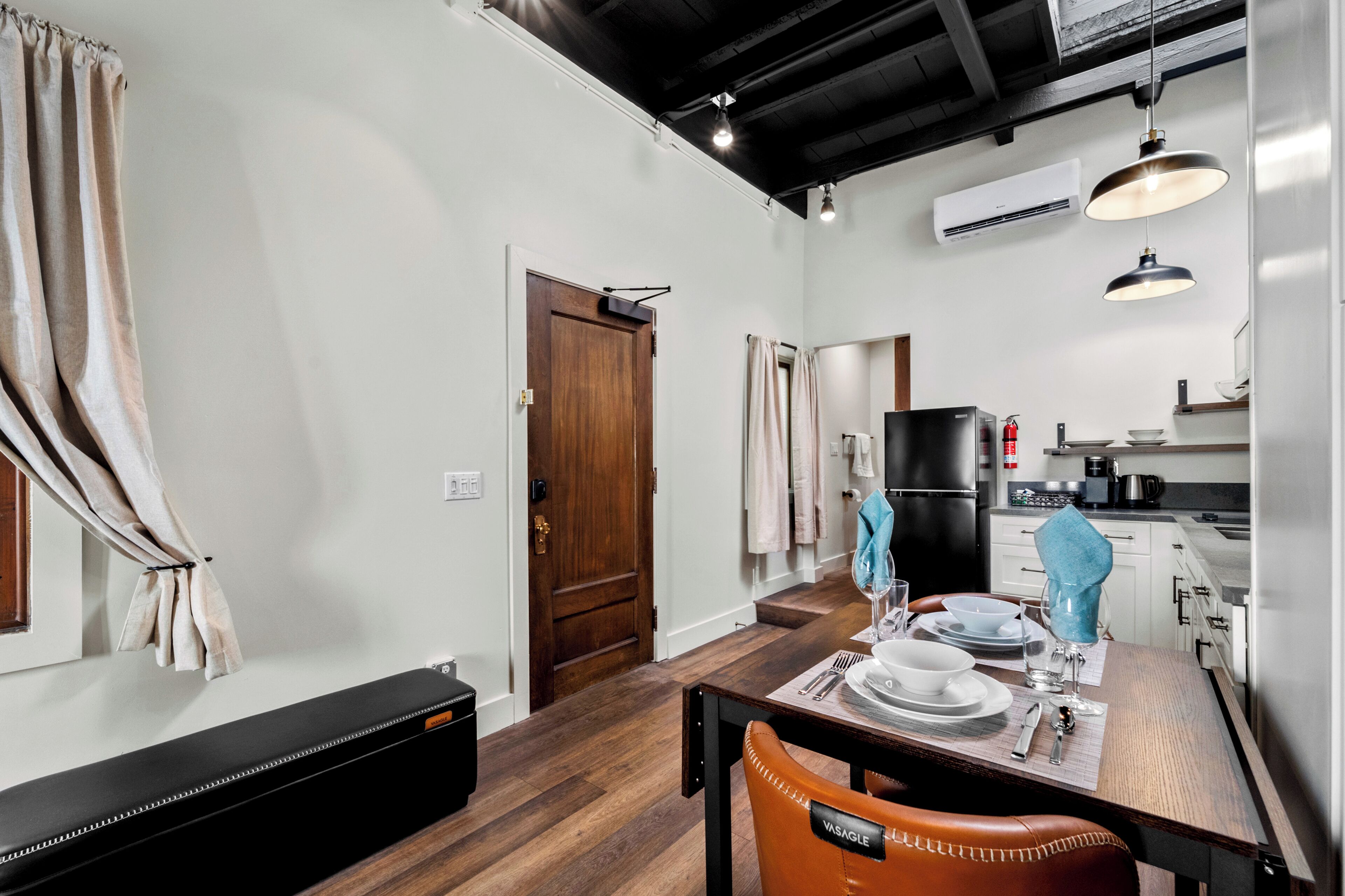 Una cocina moderna con un refrigerador negro, una cafetera y un fregadero.