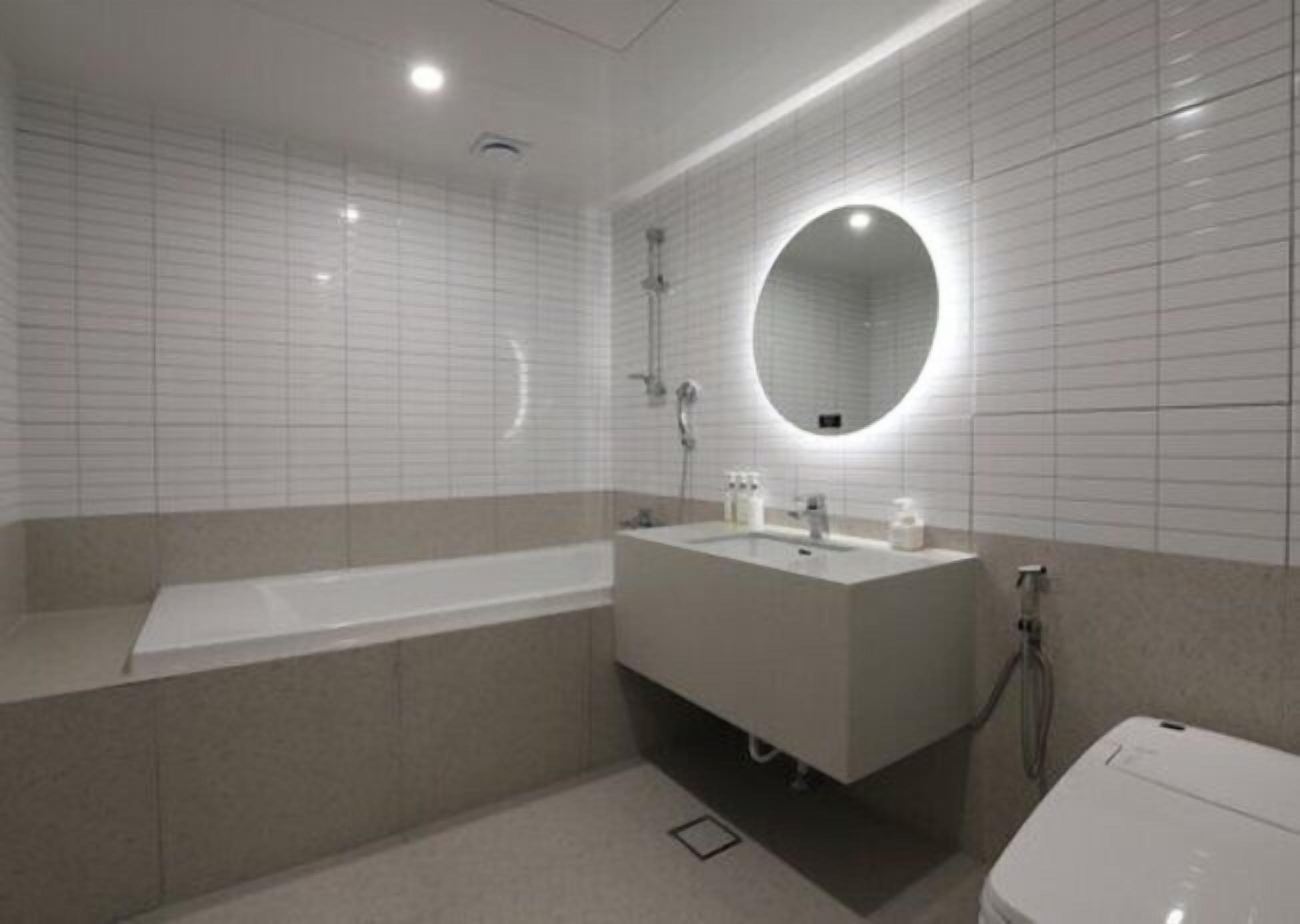 A modern bathroom with a bathtub, a sink, and a toilet.