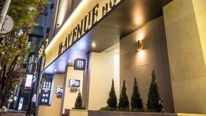 The exterior of the Haven Hotel with a modern design, including a prominent sign and a series of trees in front. - H AVENUE (Busan)