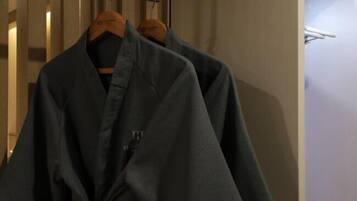 A room with a wooden wardrobe and a hanging coat rack.