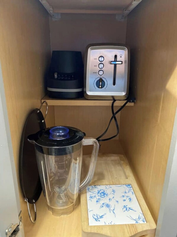 A kitchen with a coffee maker, a blender, and a small decorative item on the counter.