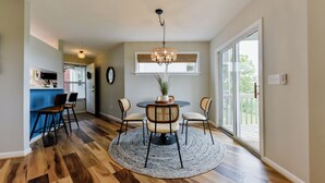 Un espace repas comprenant une table ronde, des chaises et un lustre.