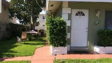 A single-story house with a front door, a small porch, and a pathway leading to the door.