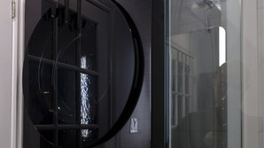 A black washing machine with a glass door, a visible control panel, and a label indicating a 20 kg capacity.