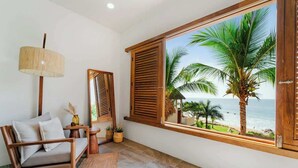 Ein Zimmer mit einer Holzsofa, einer Lampe, Blick auf den Ozean und einem Fenster mit Holzhörnern.