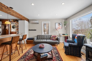 Uma sala de estar moderna com sofá, poltronas, mesa de centro e lareira.