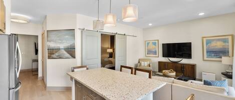A modern kitchen with granite countertops, wooden cabinets, and pendant lighting.