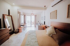 A bedroom with a bed, dresser, mirror, and a view of the outside. - Villa Marena Hotel Boutique (Coyuca de Benitez)