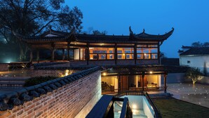 A traditional Chinese building with a tiled roof and wooden structure, featuring multiple windows and a courtyard. - Leisure Haven - Tachuan Hotel (Huangshan)