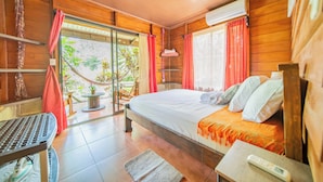 Un dormitorio de cabaña de madera con una cama, una mesa y una silla.