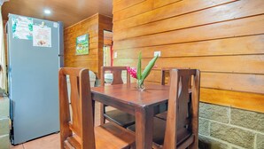 Una mesa de comedor de madera con sillas, un refrigerador y una pared con paneles de madera.