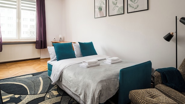 Una habitación de hotel moderna con una cama bien hecha, un sofá y un escritorio.