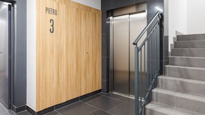 A modern elevator with a wooden panel and the name "PIETRO 3" on the wall. - Raków Stylish Apartment (Warszawa)