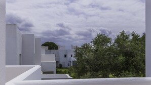 Un edificio moderno con fachada blanca y techo plano. Una escalera conduce a un nivel superior.
