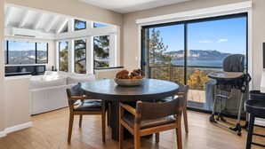 Un salon moderne avec une table ronde, un canapé et une vue sur les montagnes.