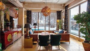 Un salon chaleureux avec un canapé, des fauteuils, une table basse et une cheminée.