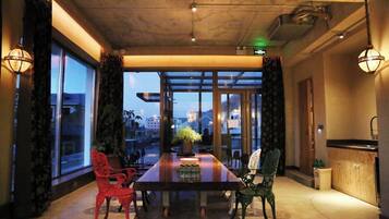 Un comedor con una mesa larga, dos sillas y vistas amplias por ventanas grandes.