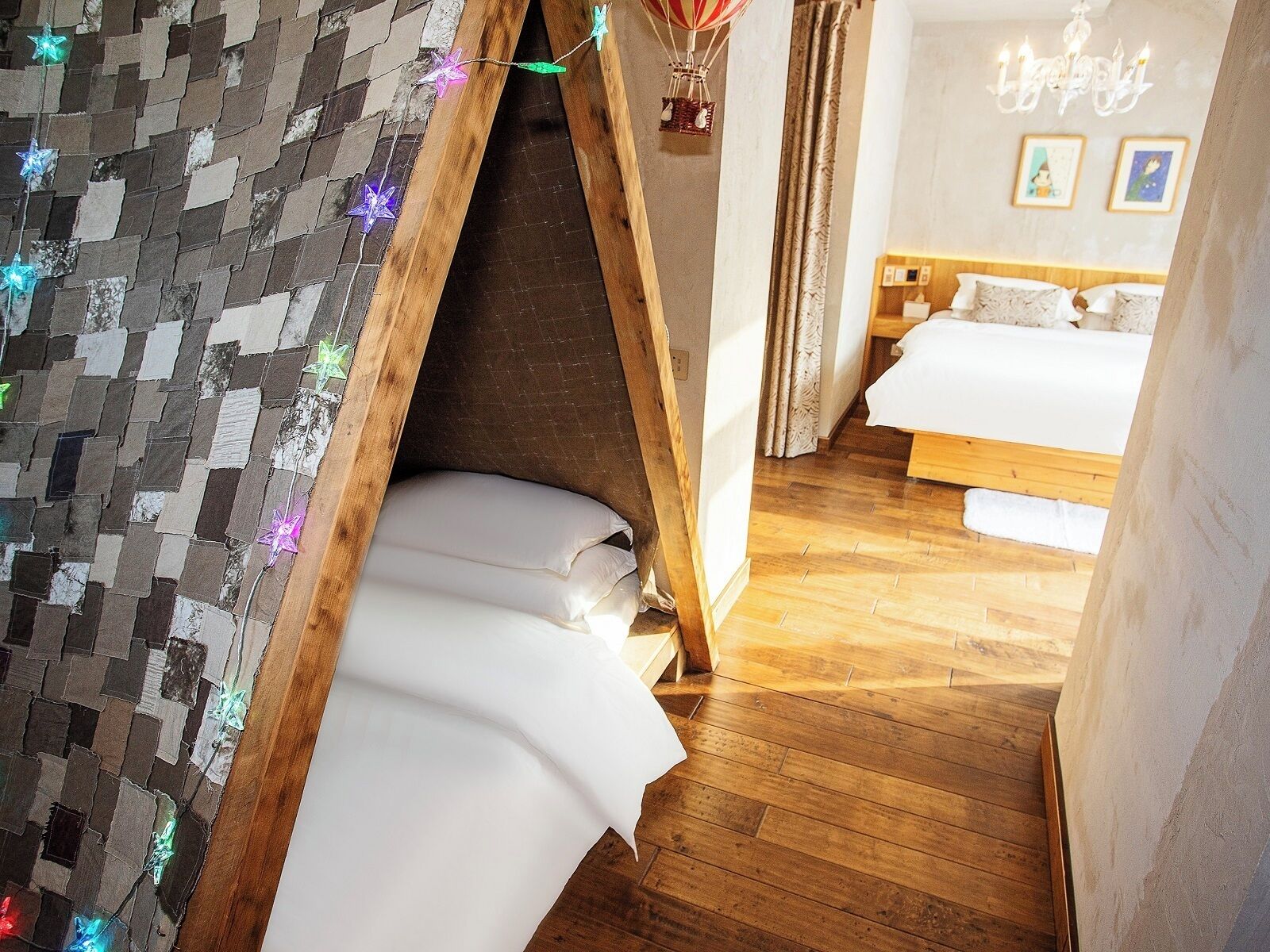 A cozy bedroom with a wooden tent-like structure, a bed with white linens, and a wooden floor.