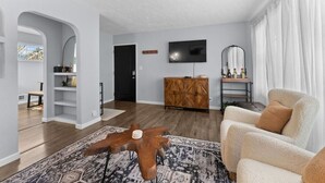 A modern living room with a wooden coffee table, a sofa, a TV, and a cabinet.