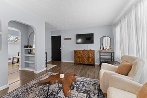 A modern living room with a wooden coffee table, a sofa, a TV, and a cabinet. - Sioux Falls Midtown Escape (Sioux Falls)