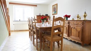 A dining area with a wooden table and chairs, a cabinet with decorative items, and a window with a view. - The "Smoking Fox". Between the Meuse and Molignée rivers, relaxation and leisure! (Onhaye)