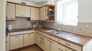 A kitchen with beige cabinets, a wooden countertop, a sink, and a window. - The "Smoking Fox". Between the Meuse and Molignée rivers, relaxation and leisure! (Onhaye)
