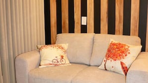 A modern living room with a sofa, two decorative pillows, and a unique coffee table with a wooden design. - Rincon Canela: Comfortable apartment in Morelia, close to the historical center (Morelia)