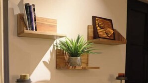 A kitchen with a wooden countertop, a black cabinet with drawers, a plant on a shelf, and a door in the background. - Rincon Canela: Comfortable apartment in Morelia, close to the historical center (Morelia)