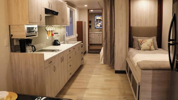 A compact hotel room with a kitchenette, a bed, and a small bathroom. - Rincon Canela: Comfortable apartment in Morelia, close to the historical center (Morelia)