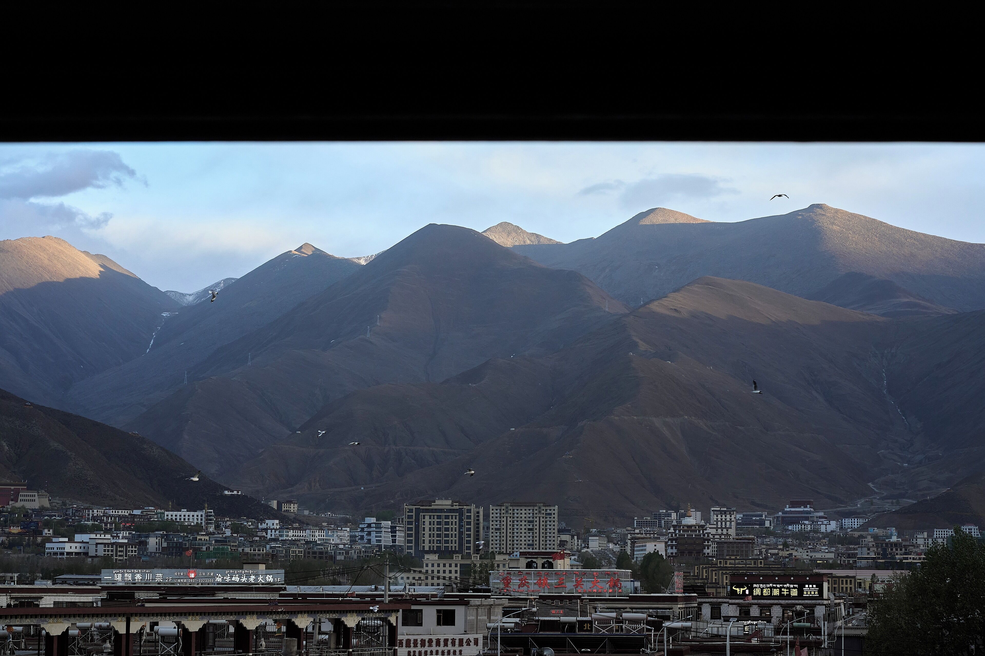 A mountainous landscape with a town in the foreground.